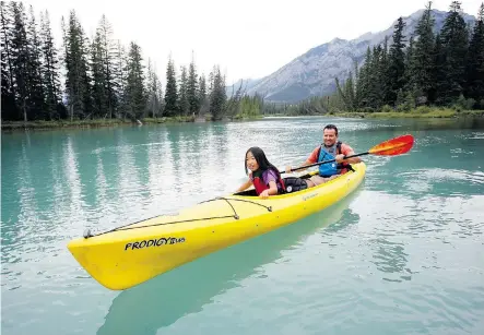  ?? Craig Douce/For the Calgary Herald ?? Mia Scovnaienc­hi, 8, and her dad, Luigi, paddle the Bow River from the Banff Canoe Club dock. Banff National Park recorded a 15 per cent increase through the end of July in the number of visitors compared with last year.