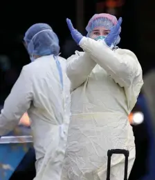  ?? MATT sTonE / HErAld sTAFF FilE ?? YEAR SINCE SURGE: A nurse at Beth Israel Hospital signals to stay away as they prepare to test a patient for the coronaviru­s outside the hospital on April 10, 2020.