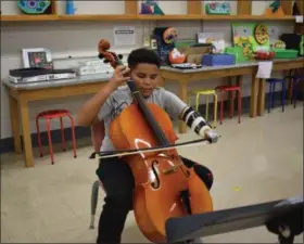  ?? BRIANA CONTRERAS — THE MORNING JOURNAL ?? Jordan Harris, 11, is a cellist and student at Eastern Heights Middle School in Elyria. Jordan was born with one hand and recently helped by a team of staff, students and those in the community to create a cello and 3D prosthetic component that would better help him control the bow of his cello. Jordan performed with his new prosthetic component at the middle school Oct. 29.