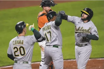  ?? Gail Burton / Associated Press ?? Oakland’s Jed Lowrie (right) celebrates his threerun home run — which gave him 17 RBIs this season — with Elvis Andrus (17) and Mark Canha in the fourth inning at Camden Yards.