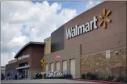  ?? AP FILE ?? People walk in and out of a Walmart store, in Dallas. President Donald Trump’s decision to abandon the Paris climate agreement will have different impacts on different US companies, depending on what they make and whether they do business overseas.