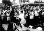  ?? Mitch Talley, File newspaper scan ?? Danny Robinson turns to head south on Wall Street after receiving the Olympic flame in front of the Gordon County Courthouse before a crowd of several thousand people.