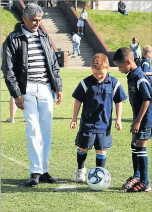  ?? Picture: SUPPLIED ?? MASTER AT WORK: Vissie Chetty prepares to kick off a match while two Merrifield Primary pupils stand ready during the 2012 Vissie Chetty Grade One soccer festival at Crewe Primary School
