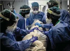  ??  ?? Turning, or proning, a Covid patient at the Royal Free hospital