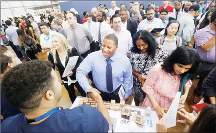  ?? (AP) ?? In this file photo, job seeker Cedric Edwards, (center), shakes hands with recruiter Allen Lewis, (left), during an Amazon job fair in Dallas. On Oct 2, payroll processor ADP reports how many jobs private employers added in September.