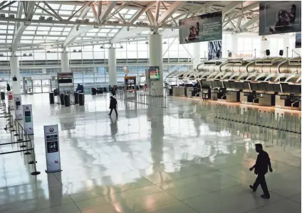  ?? SPENCER PLATT/GETTY IMAGES ?? People walk through a sparsely populated internatio­nal departure terminal on Saturday at John F. Kennedy Airport in New York City as concern over the coronaviru­s grows.