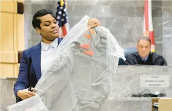  ?? FLORIDA SUN SENTINEL PHOTOS AMY BETH BENNETT/SOUTH ?? During her closing arguments on Tuesday, Assistant State Attorney Pascale Achille holds up the sweatshirt worn by the victim known as XXXTentaci­on at the time of his murder, showing orange markers noting bullet holes.