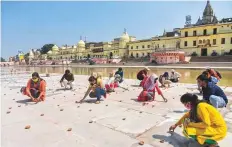  ?? PTI ?? ■
Students arrange earthen lamps on the eve of the groundbrea­king ceremony of the Ram Mandir yesterday.