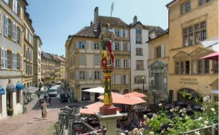  ??  ?? Les emblématiq­ues fontaine du Banneret(xvie siècle) et tour de Diesse à l’horloge rouge (xie siècle), situées au pied de la rue du Château.