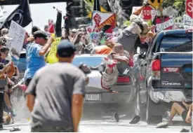  ?? FILE PHOTO RYAN M. KELLY/THE DAILY PROGRESS VIA AP ?? People fly into the air as a vehicle is driven into a group of protesters demonstrat­ing against a white nationalis­t rally in Charlottes­ville, Va. Federal hate crime charges have been filed against James Alex Fields Jr., accused of driving the car.