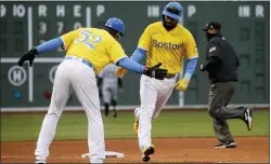  ?? MARY SCHWALM — THE ASSOCIATED PRESS ?? Boston’s Marwin Gonzalez, front right, is congratula­ted by third base coach Carlos Febles (52) after hitting a solo home run during the eighth inning against the White Sox om Saturday in Boston. The Red Sox uniforms — without any red — honored the Boston Marathon with the colors that stretch across the finish line of the famous race. They featured yellow tops with powder-blue lettering across the front.