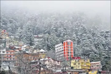  ?? DEEPAK SANSTA /HT ?? ■ Houses and trees covered in snow at Jakhu in Shimla on Tuesday. The Mall Road and Jakhu Hill witnessed around 8cm snow.
