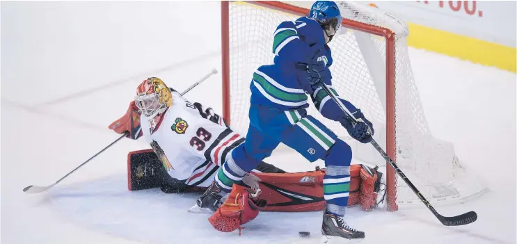  ?? — THE CANADIAN PRESS ?? Blackhawks’ goalie Scott Darling loses his glove but manages to turn back Vancouver’s Loui Eriksson during overtime on Saturday night at Rogers Arena.