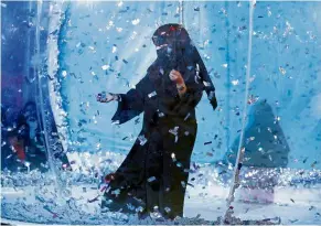  ??  ?? ‘Staggering pivot’: a woman collecting silver tickets at an amusement park during the festival on the outskirts of riyadh.