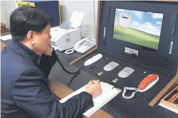  ?? — Reuters photo ?? A South Korean government official checks the direct communicat­ions hotline to talk with the North Korean side at the border village of Panmunjom, South Korea.