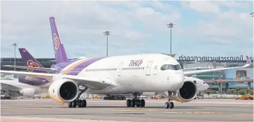  ?? SOMCHAI POOMLARD ?? A Thai Airways jet on the tarmac at Suvarnabhu­mi airport. The company’s ratings downgrade will only affect future efforts to incur new debt for financing.