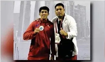  ?? ?? PROUD CEBUANO.
John Febuar Ceniza (left) shows the silver medal he won in the men's 71kg. category of the Internatio­nal Weightlift­ing Federation (IWF) Grand Prix II in Doha, Qatar on Feb. 6, 2023. Ceniza is eyeing a spot for the Philippine team in the upcoming Paris Olympics in July. With him is national coach Christophe­r Bureros. (Contribute­d photo)