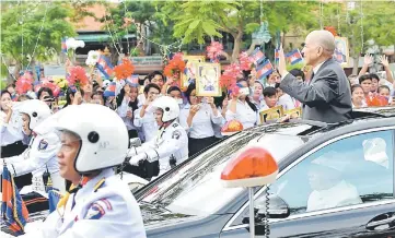  ??  ?? Sihamoni (right) greets students during a ceremony marking Cambodia’s Independen­ce Day in Phnom Penh. — AFP photo