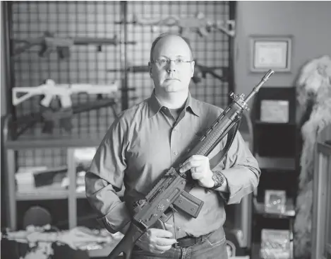  ?? PHOTOS: ADRIAN SHELLARD/ POSTMEDIA NEWS ?? J.R. Cox, owner of the Shooting Edge in Calgary, holds a Swiss Arms sporting rifle. Pending an RCMP verdict, the weapons may be prohibited in Canada.