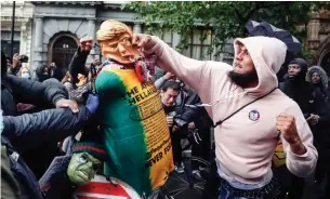  ?? FRANK AUGSTEIN THE ASSOCIATED PRESS ?? A man punches a puppet depicting U.S. President Donald Trump during a protest in London on June 6. Trump has taken to referring to the coronaviru­s pandemic in the past tense.