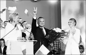  ??  ?? De Poolse president Andrzej Duda met een bouquet rozen in zijn hand.(Foto: NRC)