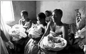  ?? TSVANGIRAY­I MUKWAZHI/AP ?? Mothers hold their babies Saturday in a tiny apartment in the poor suburb of Mbare near Harare after delivering with the help of 72-year old grandmothe­r Esther Zinyoro Gwena.