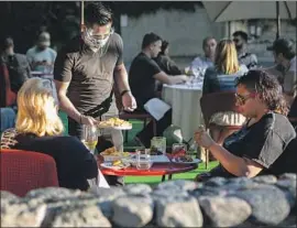  ?? Jason Armond Los Angeles Times ?? PEOPLE HAVE drinks and dine on the outdoor patio at La Boheme in West Hollywood on Wednesday. New restaurant closures have been a blow to owners.