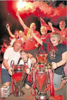  ??  ?? JOYOUS LOT Liverpool supporters celebrate outside of Anfield stadium on Thursday after the team clinched the English Premier League title. Liverpool took the title after Manchester City failed to beat Chelsea on Wednesday evening.