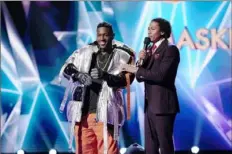  ?? Michael Becker/FOX ?? Steelers receiver Antonio Brown as a hip-hop hippo, with host Nick Cannon, is revealed to be “The Masked Singer” on Fox’s reality series debut Jan. 2.