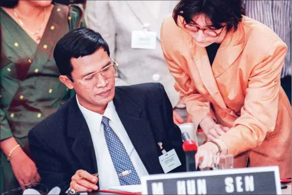  ?? GERARD FOUET/AFP ?? Hun Sen signs the Agreements on a Comprehens­ive Political Settlement of the Cambodia Conflict, more commonly known as the Paris Peace Accords, on October 23,1991, a treaty which ended 21 years of civil war in the Kingdom.