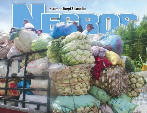  ?? ARCHIE REY ALIPALO/PN ?? VEGGIES FROM CANLAON. Farmers ride on a truck loaded with fresh vegetables from Canlaon City, Negros Oriental. They are on their way to Bacolod City, the capital of the adjacent Negros Occidental province — their biggest market, they say.