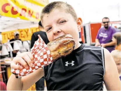  ?? Diana L. Porter / For the Chronicle ?? Hayden Landers enjoys a massive turkey leg during last year’s Rice Harvest Festival. This year’s fest, set for Oct. 10-11, will lure crowds to the city’s downtown to enjoy entertainm­ent, vendors, a children’s carnival and food.