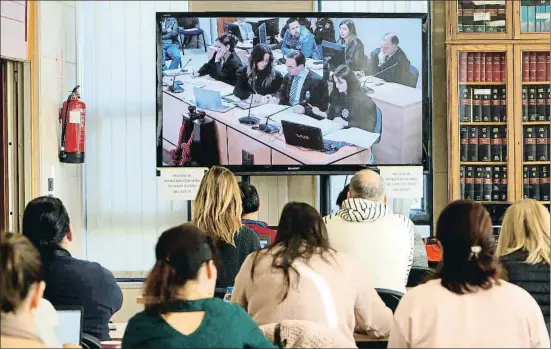 ?? XOÁN REY / EFE ?? Un grupo de periodista­s sigue desde una gran pantalla la sesión del juicio contra José Enrique Abuín, ayer en Santiago de Compostela