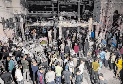  ?? EFE ?? Gaza. Palestinos buscan a las víctimas entre los escombros después de que un ataque aéreo israelí en Rafah.