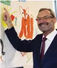  ??  ?? Bürgermeis­ter Manfred Wolf freut sich über das bunte Plakat der Kinder.