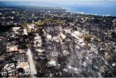  ?? AntonIs nIkoloPoul­os/EurokInIss­I VIA AP ?? This Wednesday aerial photo shows burnt houses and trees following a wildfire in Mati, east of Athens.