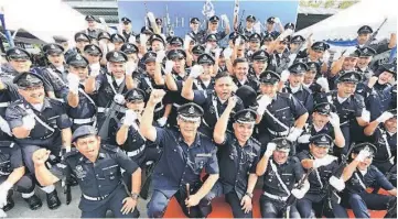  ??  ?? Police personnel celebrate the 208th Police Day by posing for a group photo following yesterday’s gathering at state police headquarte­rs to mark the event.