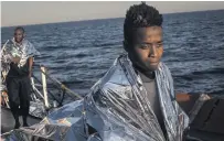  ?? CHRIS MCGRATH, GETTY IMAGES ?? Refugees and migrants who were headed toward Europe warm up aboard the Migrant Offshore Aid Station Phoenix vessel after being rescued at sea June 10 off Lampedusa, Italy.