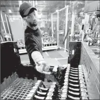  ?? AP/ROGELIO V. SOLIS ?? A worker at a Nissan Motor Corp. warehouse in Canton, Miss., prepares parts to be shipped to a nearby Nissan assembly plant in December. The Federal Reserve said manufactur­ing output fell 0.2 percent in February.