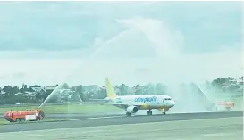  ?? SUNSTAR FOTO / GILFORD A. DOQUILA ?? DAILY TO CLARK. A Cebu Pacific A320 is given a water salute during the launch of the daily flights between Davao City and Clark.