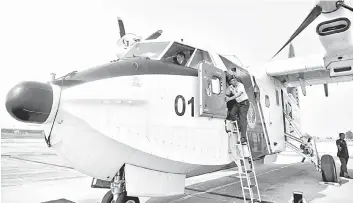  ??  ?? Zubil Mat Som seen getting onto the Bombardier CL- 415 aircraft to assist in the firefighti­ng operations around Sri Aman yesterday.