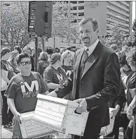  ?? MEDIA OHIO] [MARC KOVAC/GATEHOUSE ?? Henry Nicholas, who organized a successful campaign for Marsy’s Law in California after his sister’s slaying, carries a box of petition signatures to the secretary of state’s office Thursday, joined by other supporters of the proposed amendment to the...