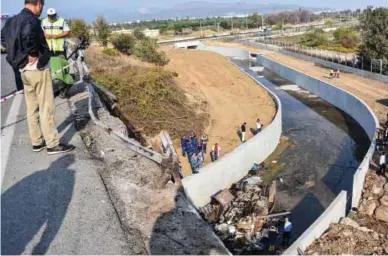  ??  ?? Police forensic experts examine the wreckage of the truck in Izmir.