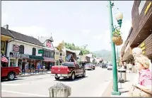  ?? (AP) ?? People wait to cross the street in Gatlinburg, Tenn.