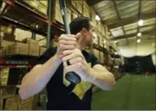  ?? TED S. WARREN — THE ASSOCIATED PRESS ?? Brent Weidenbach, director of product management for Axe Bat, poses for a photo holding one of his company’s baseball bats in the batting cage at the company’s warehouse in Renton, Wash. Axe Bat is trying to revolution­ize baseball with a simple concept...