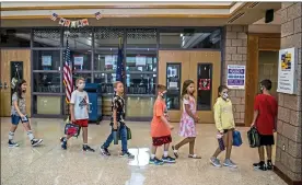  ?? ALEXANDRA WIMLEY — THE ASSOCIATED PRESS ?? A class of students walks through the hallway during the first day of school at Mars Area Elementary School, Wednesday, in Mars, Pa.