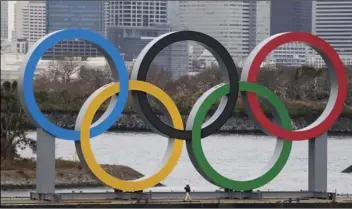  ?? AP PHOTO/JAE C. HONG ?? A worker is dwarfed by the Olympics Rings on a barge on Jan. 17, in the Odaiba district of Tokyo.