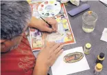  ??  ?? Ted Grano paints Our Lady of Guadalupe on a tile in memory of his parents, who were longtime Corrales residents. Grano was doing the work recently at the Corrales senior center.