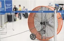  ?? ?? A large fan at the United ticket counter in Terminal B was among a series of temporary measures taken to alleviate the heat Tuesday.