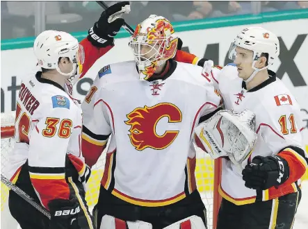  ?? LM OTERO/THE ASSOCIATED PRESS ?? Flames goalie Chad Johnson, centre, celebrates with teammates Troy Brouwer, left, and Mikael Backlund after a win against the Stars in Dallas last month. Johnson grew up a big Jarome Iginla fan and may get one final chance to play against the former...